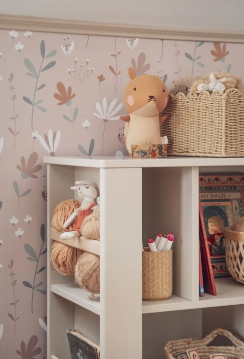 Boczne półki regału niskiego Miloo szampańskiego z książkami i dekoracjami