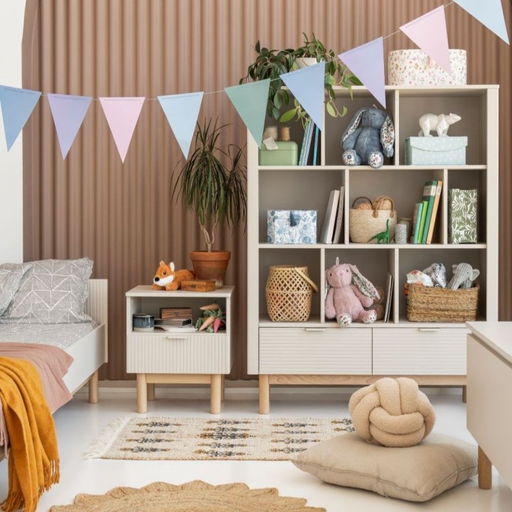 Regał szeroki Miloo szampański w pokoju dziecka obok łóżka i stolika nocnego