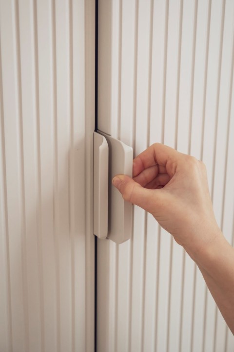 Zbliżenie na uchwyty i ryflowane fronty szafy 2-drzwiowej Miloo szampańskiej