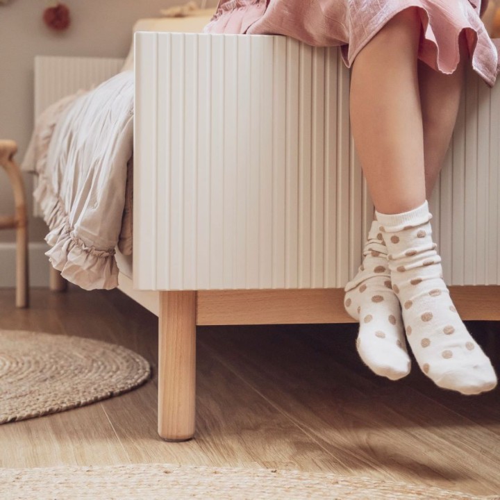 Detal ryflowanego szczytu łóżka Miloo na bukowych nogach