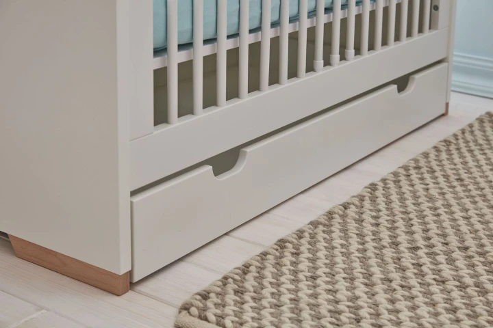 Biała szuflada pod łóżeczkiem Snap z bukowymi nóżkami